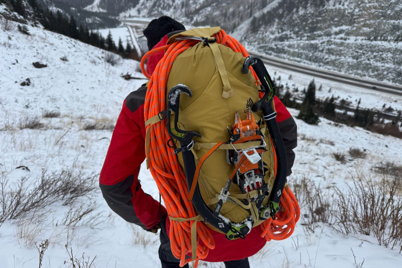 Gregory Alpinisto 30 pack loaded with rope and ice tools on a snowy mountain