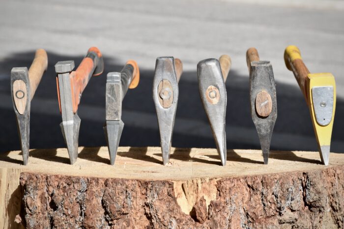 showing a lineup of seven different splitting axe heads