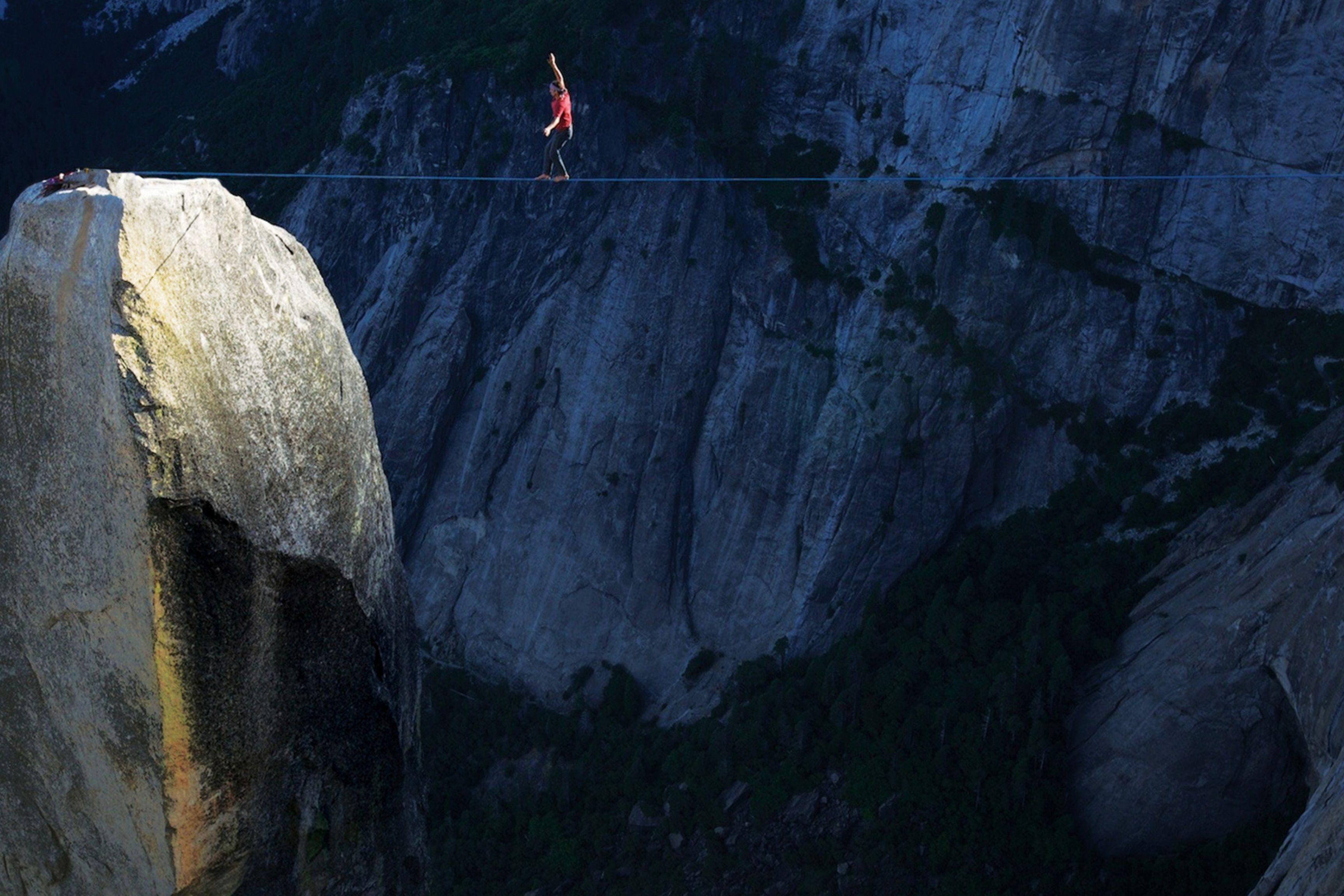 person walks across a highline