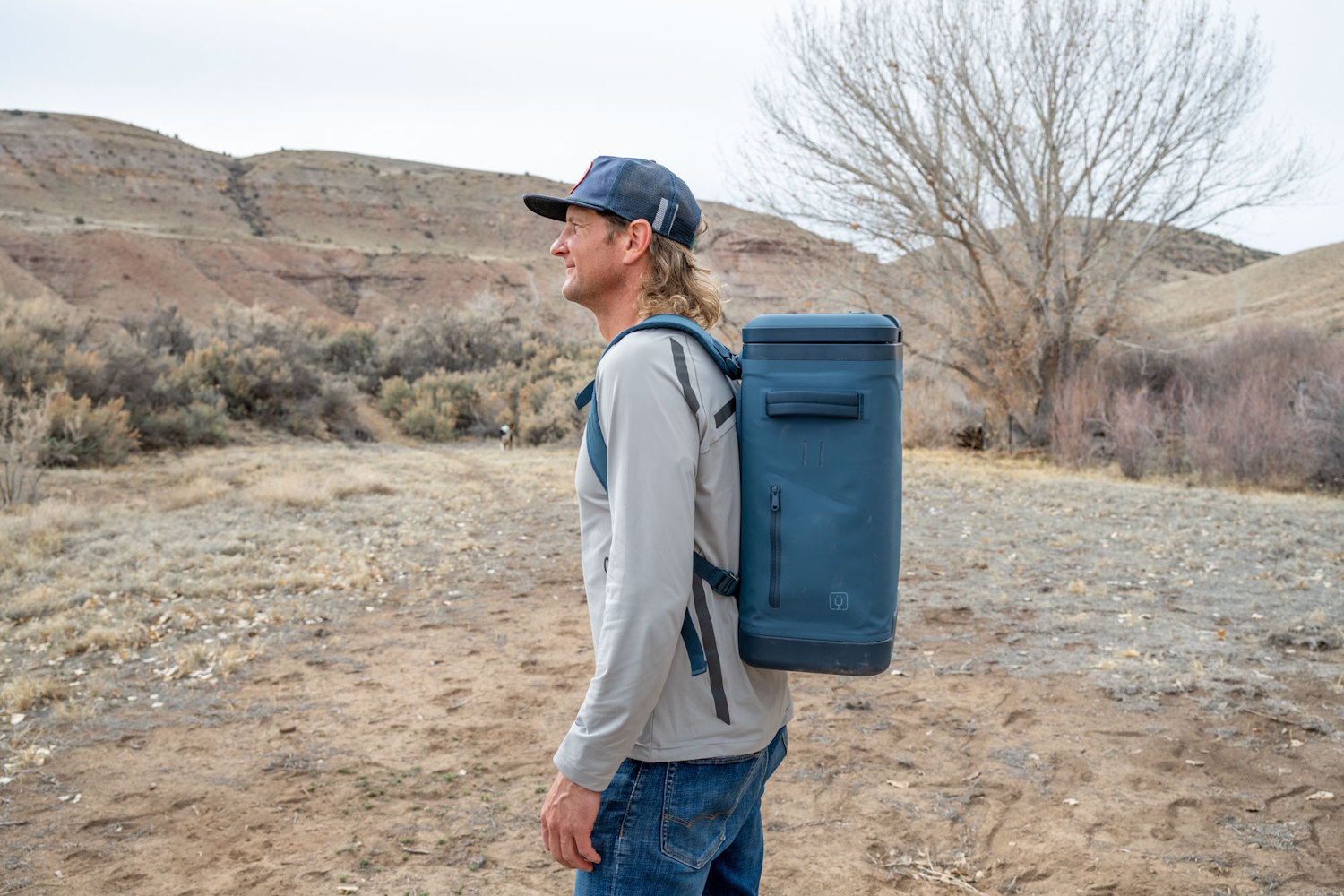 Side profile of a man wearing the BrüMate MagPack while walking in a desert landscape
