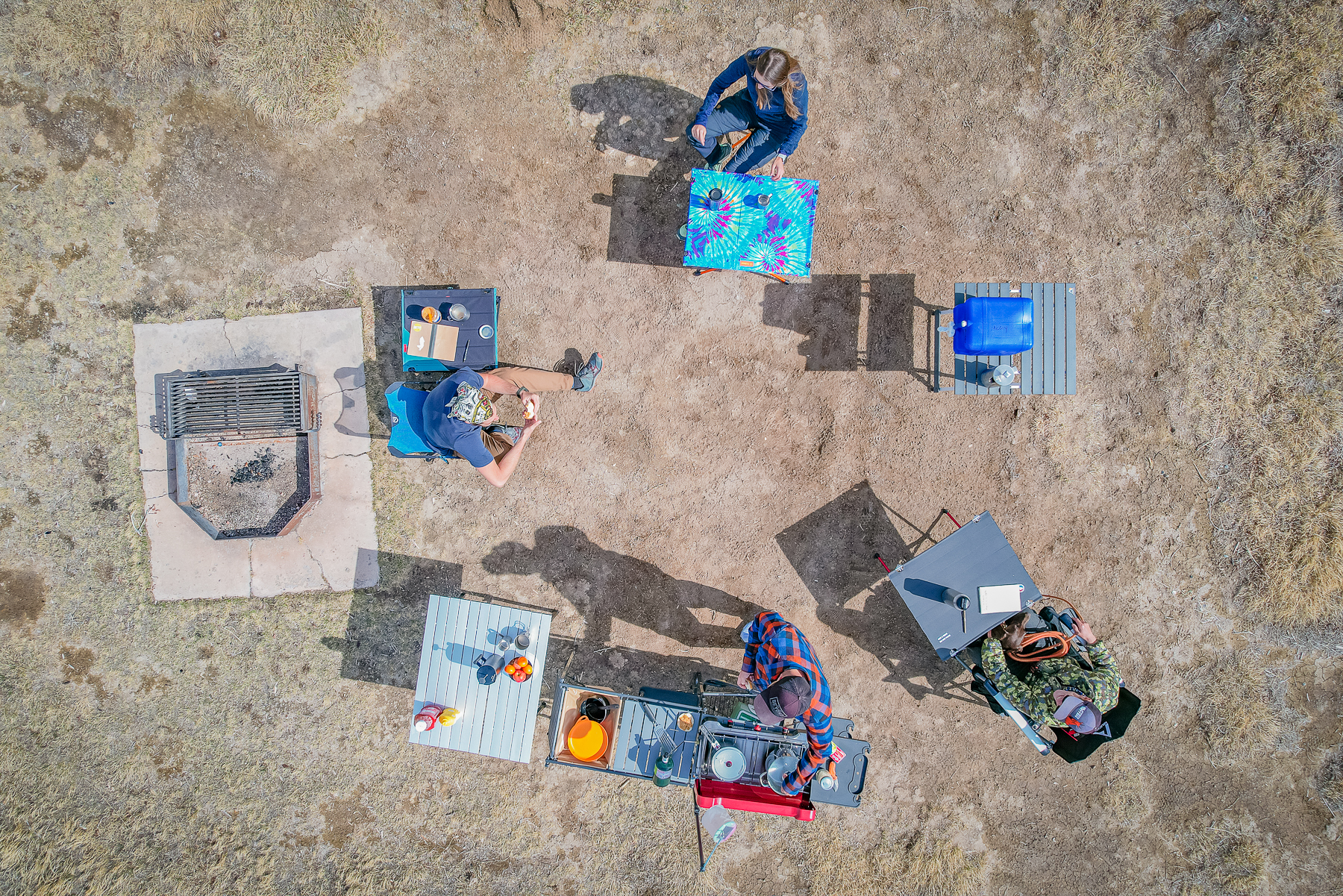 Birds eye drone view of campers, camp chairs, and tables