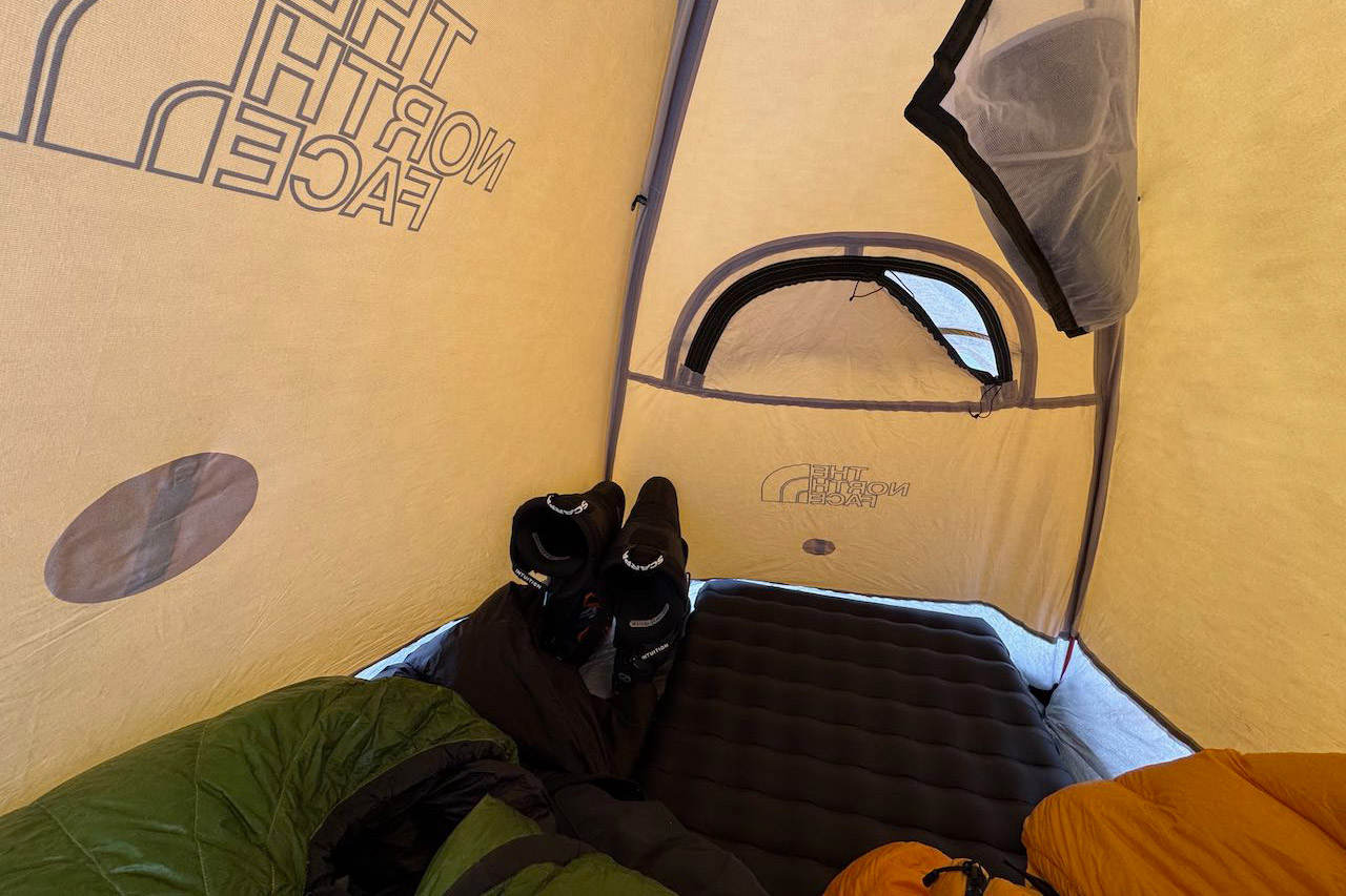 Inside view of tent with sleeping pad boots and bags arranged