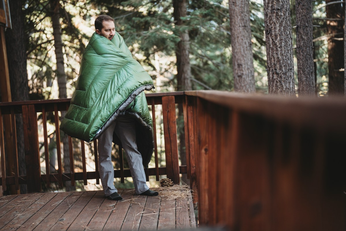 a man getting wrapped up in the enlightened equipment revelation quilt