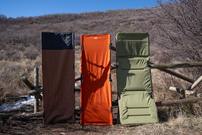 three camping cots set on end to display the sleeping surfaces provided