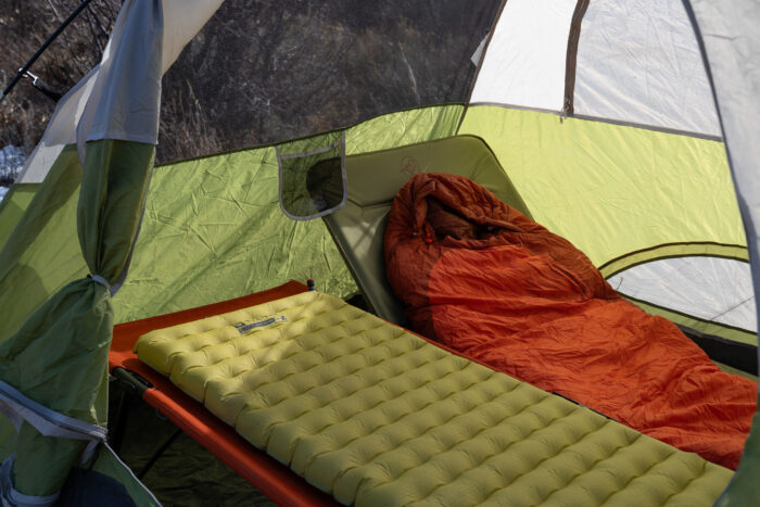 the rei campwell cot and stio folding cot set up together inside a coleman tent while testing in colorado