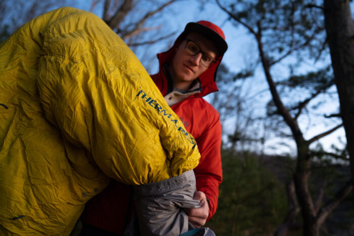 gearjunkie tester chris carter removes a therm-a-rest parsec sleeping bag from it's stuff sack while backpacking 