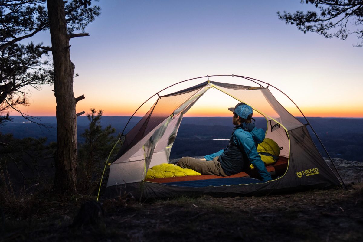 gearjunkie tester in a backpacking tent and a backpacking sleeping pad during sunset