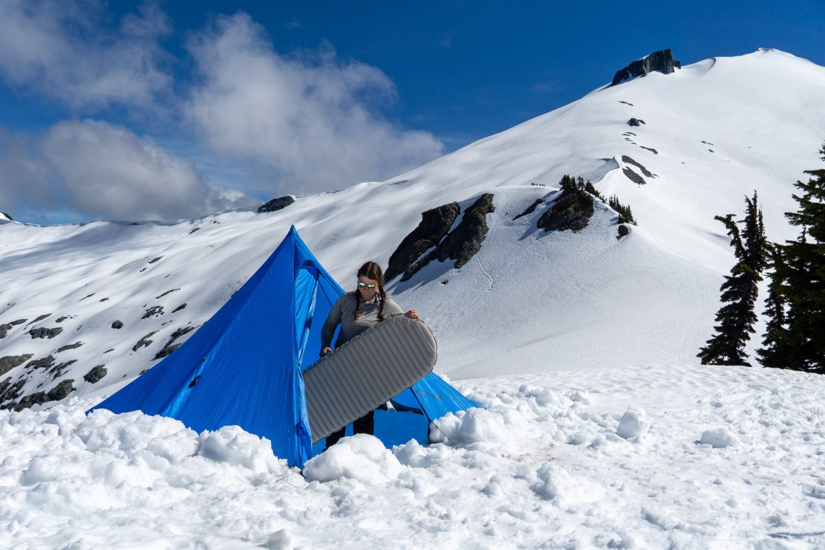 gearjunkie tester sets up a therm-a-rest xtherm pad in a black diamond tent while camping in the snow of the north cascades