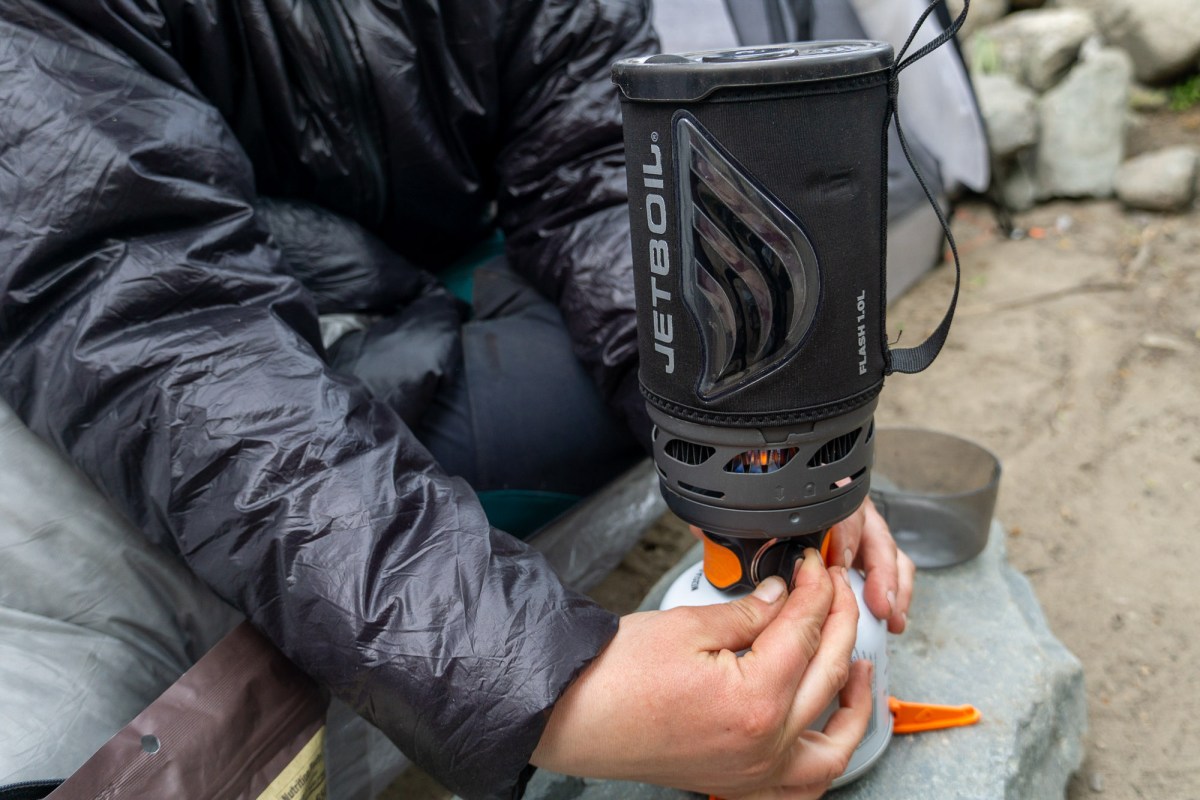 a backpacker in patagonia adjusts the appliance-like control knob of the jetboil flash stove system during testing