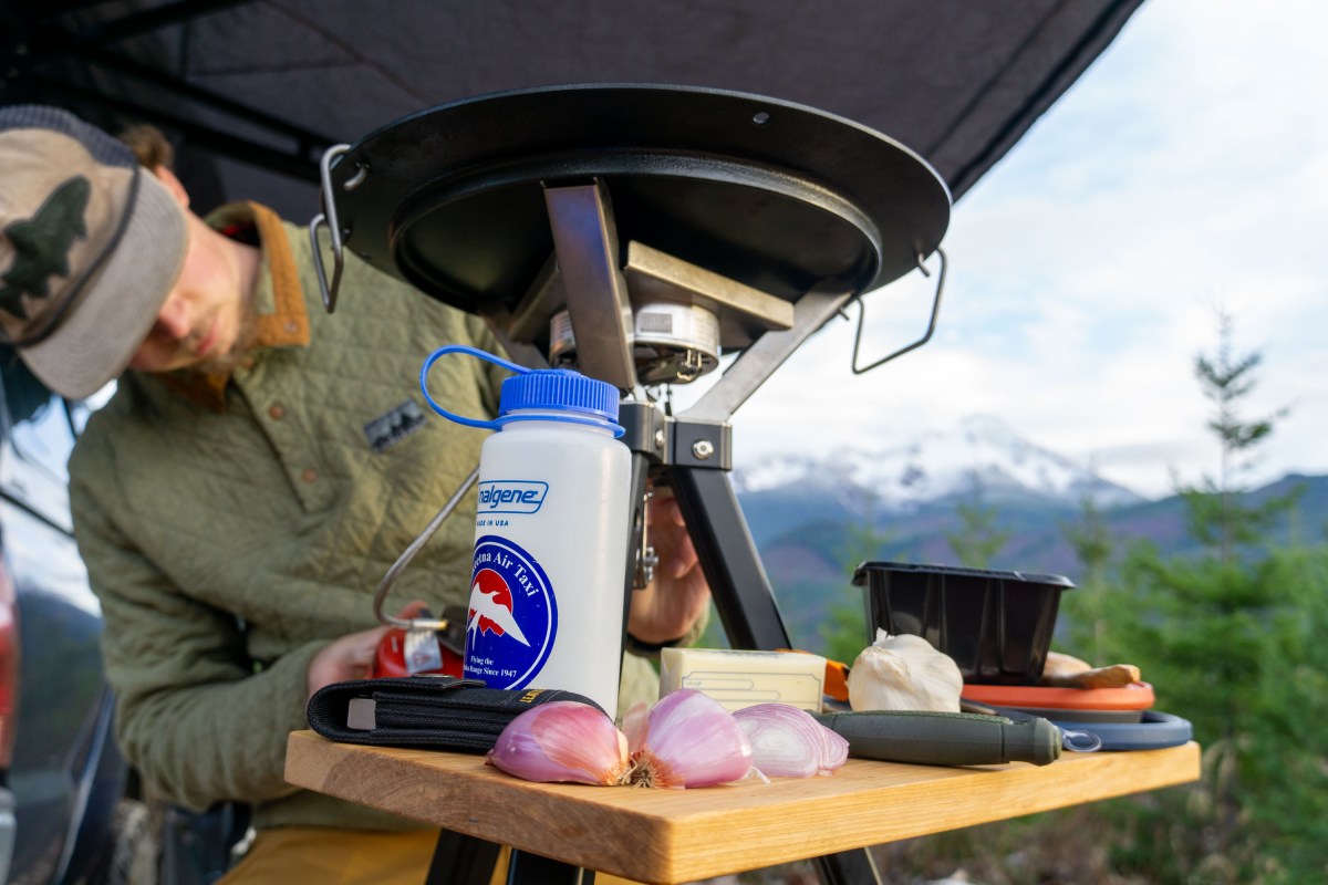 gearjunkie senior editor nick belcaster adjusts the ikamper disco stove while cooking steak au poivre