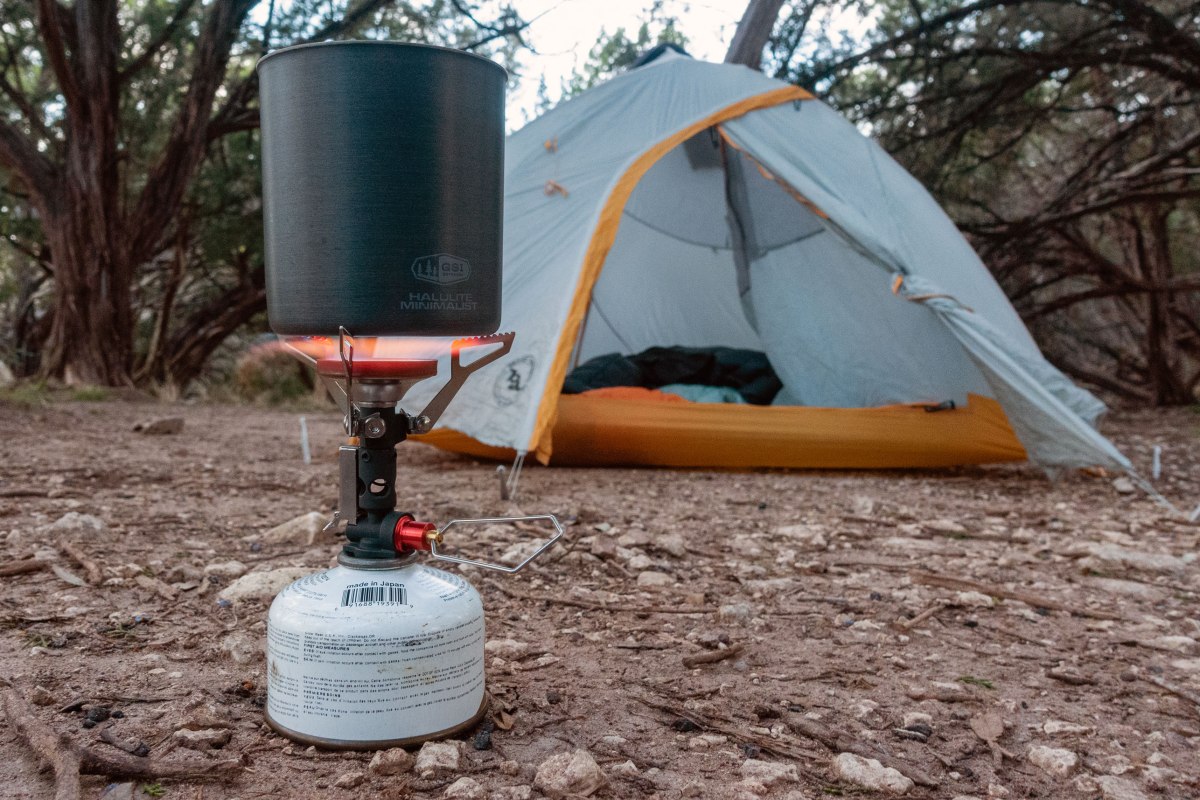 the MSR Pocket Deluxe camp stove boiling water in a gsi pot in front of a Big Agnes tent while testing