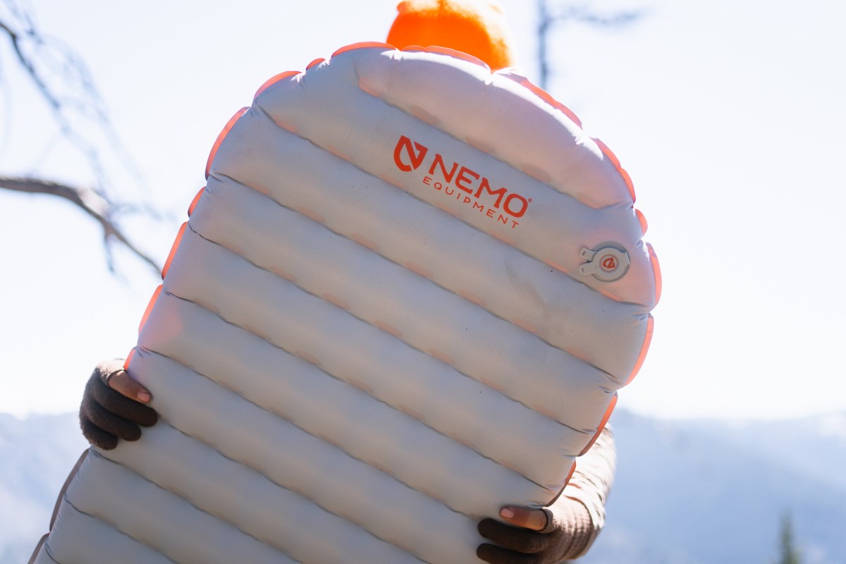 NEMO Tensor sleeping pad held up outdoors with the valve and baffle design visible