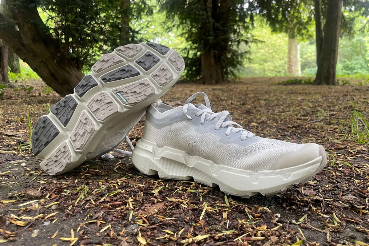 Cloudsoma trail shoes on a forest path with one shoe showing the lugged outsole