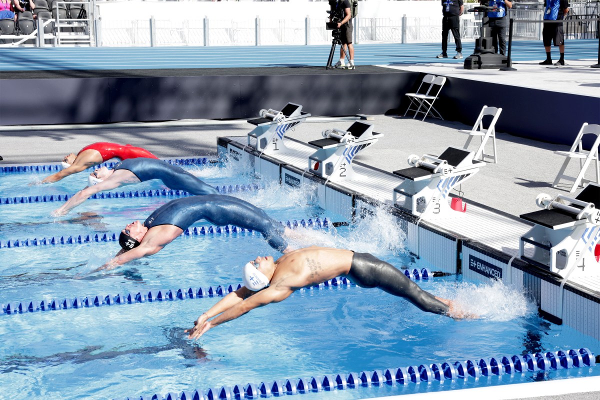 Swimmers diving into backstroke race