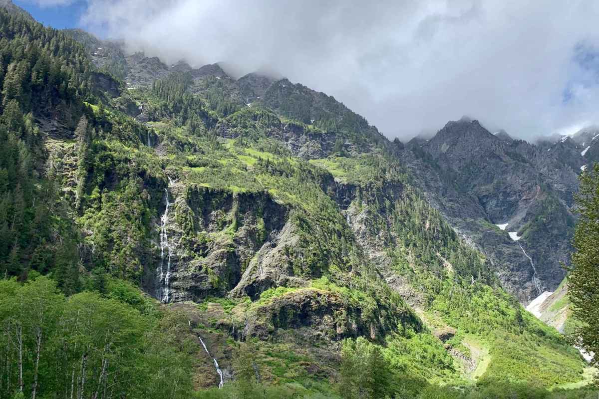 foggy, mountainous landscape with greenery and waterfalls