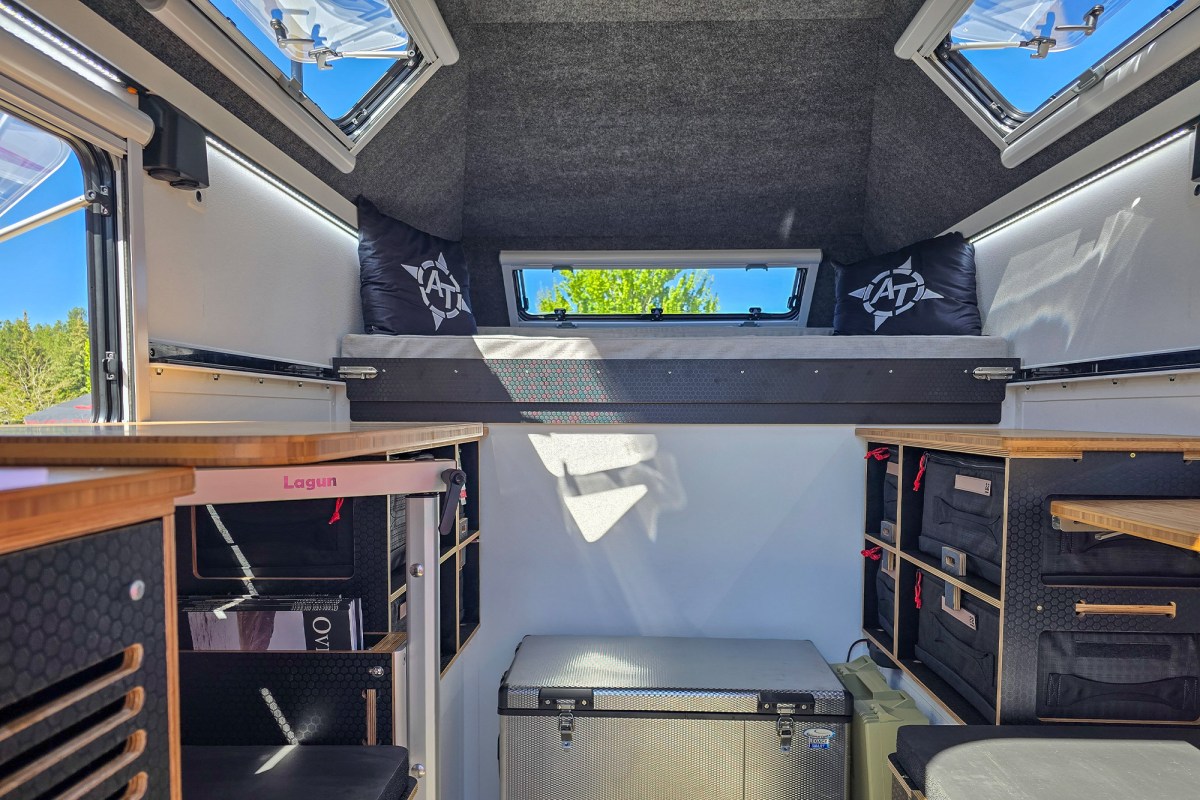 Interior of the AT Overland Aterra ASI camper with sleeping space, storage, skylights, and side counters