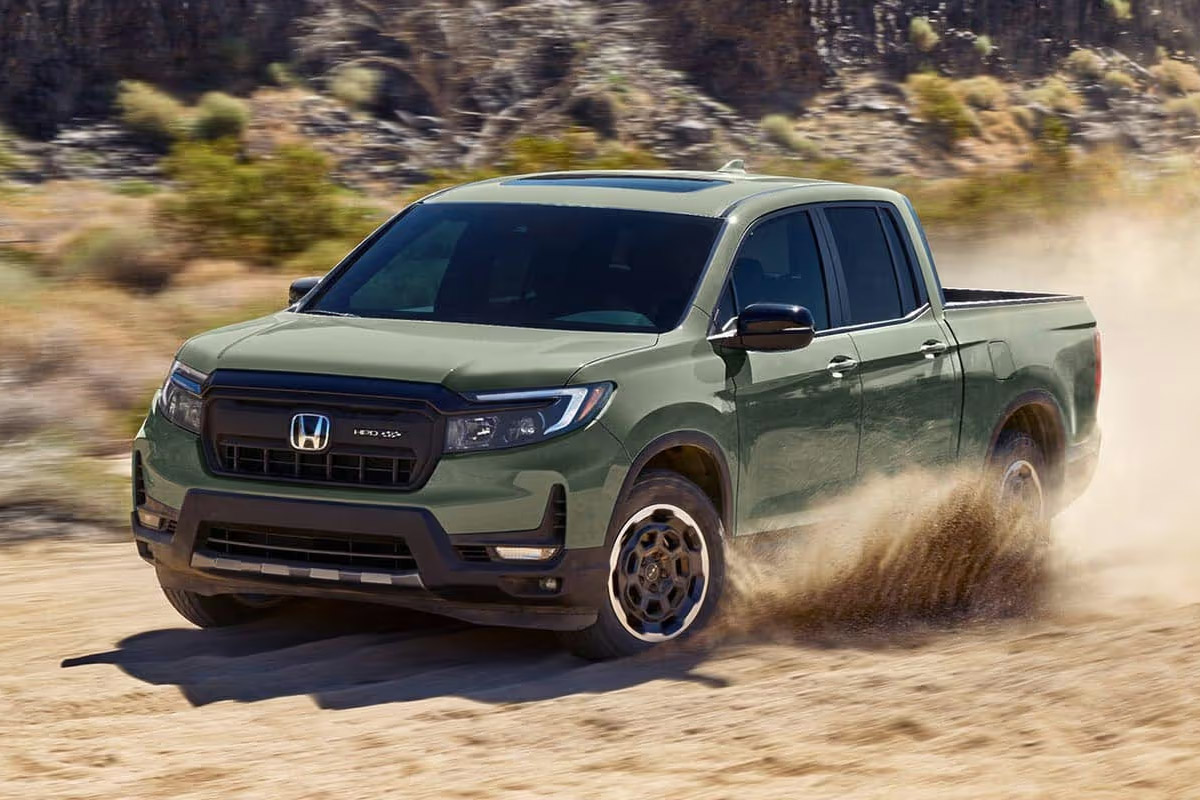 Honda Ridgeline driving fast on a dusty dirt road