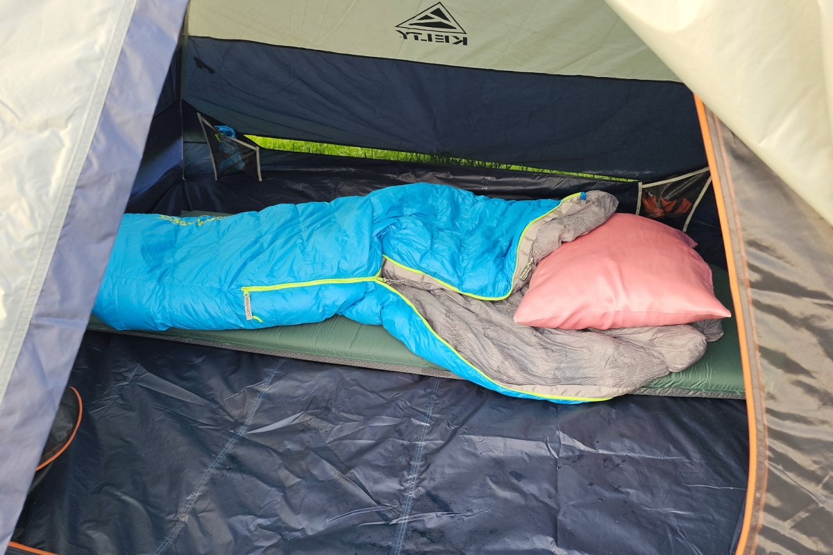 Kelty tent interior set up with a sleeping pad, sleeping bag, and pillow