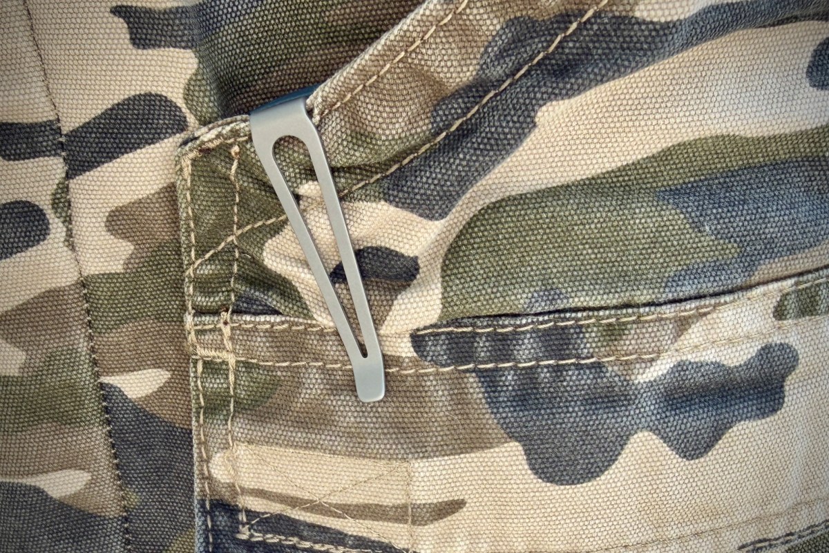 Pocket clip of the Madrone knife attached to a camouflage gear bag