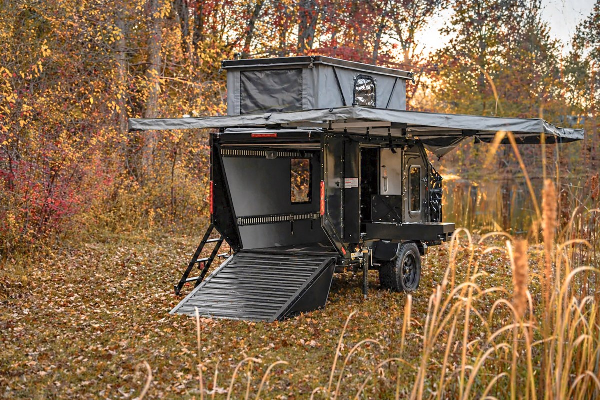 Mission Overland Trail Dog trailer set up with rear ramp and awning in an autumn campsite