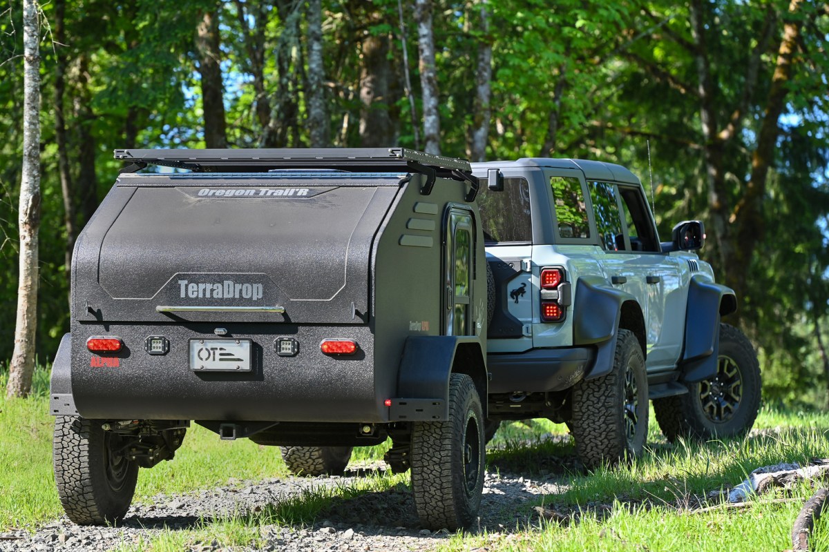 Oregon Trail’R TerraDrop trailer towed by a Bronco through a wooded trail