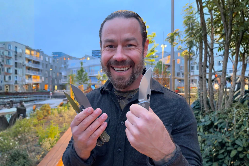 Man smiling while holding three GiantMouse Pontius knives outdoors