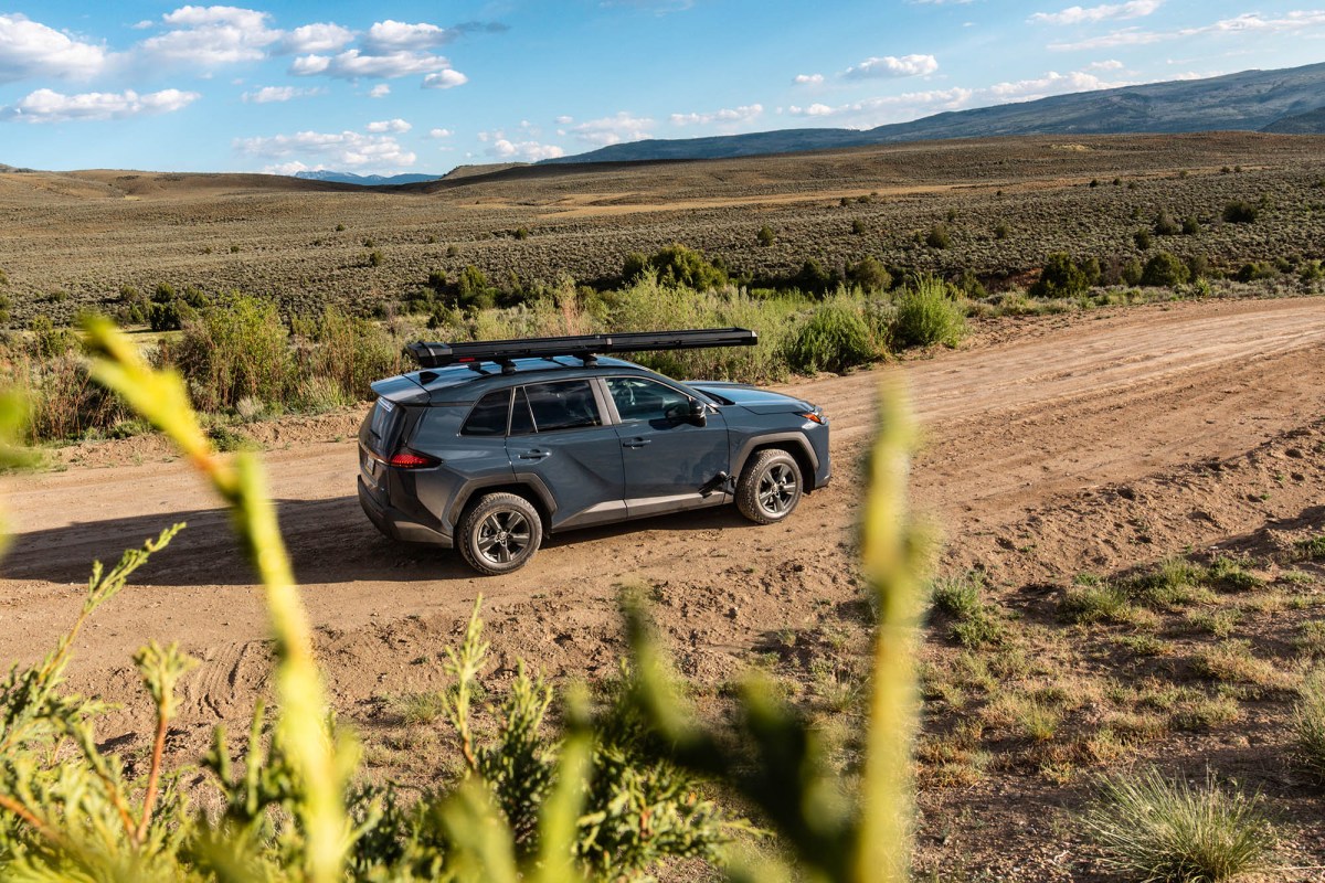 Toyota RAV4 driving on a dirt road through open terrain