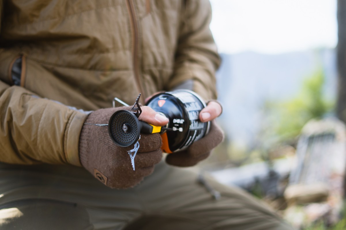 A camper attaches the Roughridge stove burner to a fuel canister