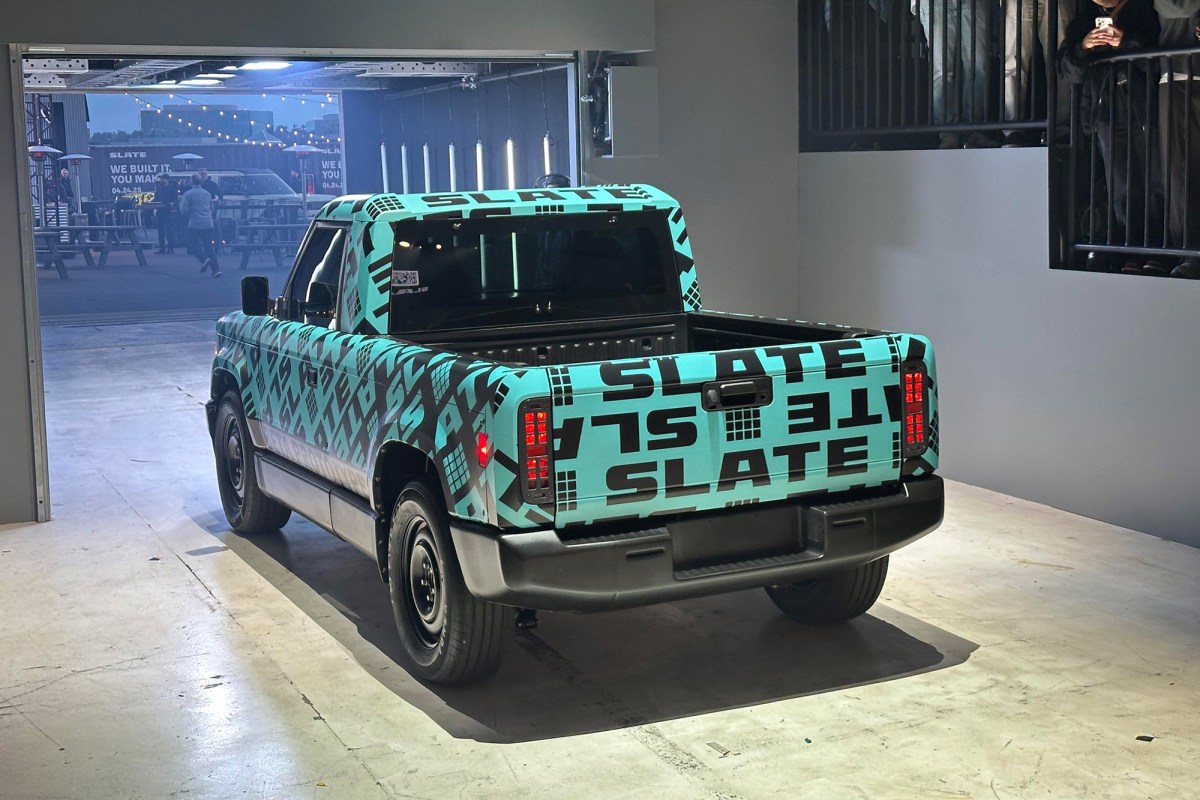 Rear three-quarter view of a teal camouflaged Slate pickup indoors