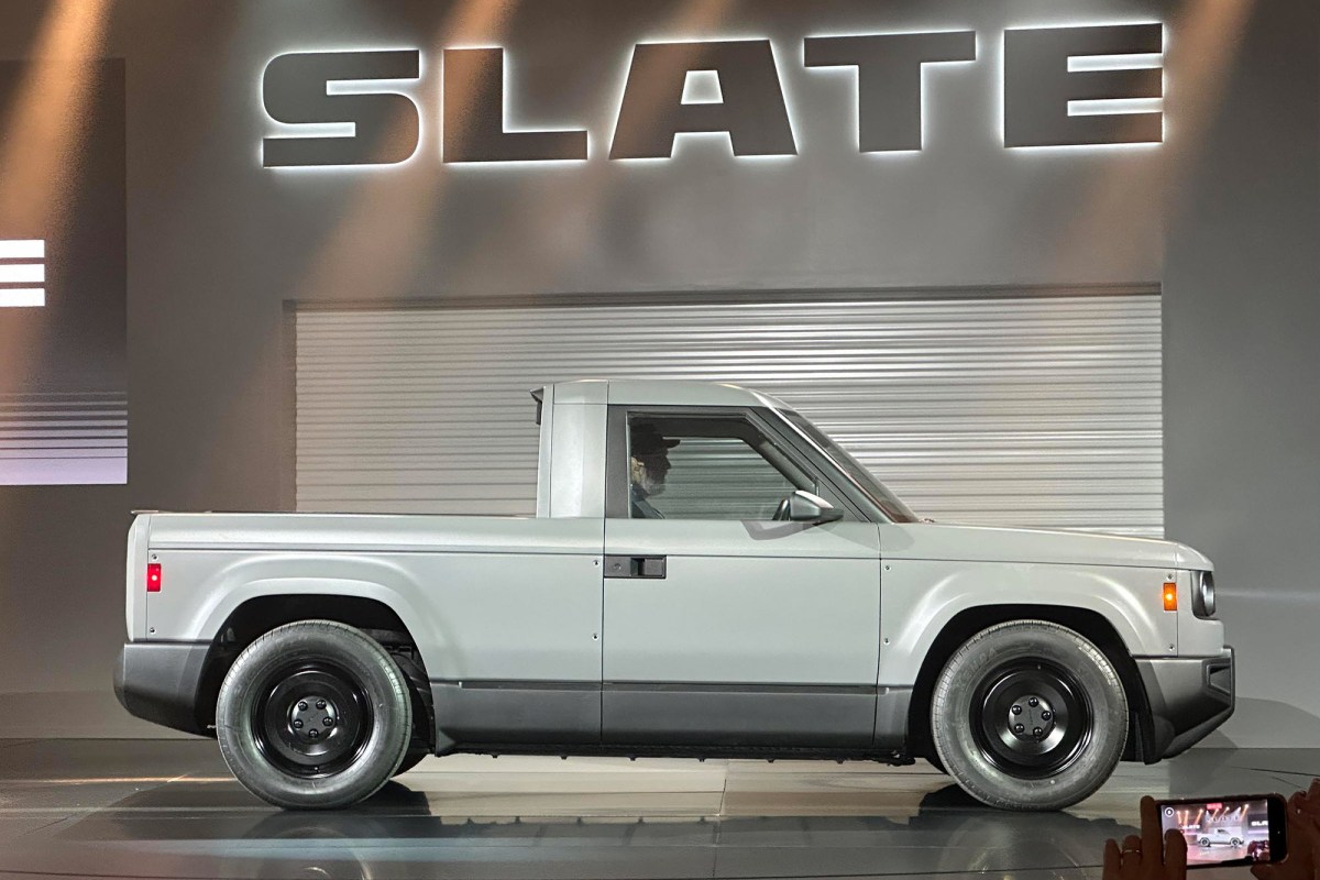 Slate pickup shown in profile under a large illuminated Slate sign