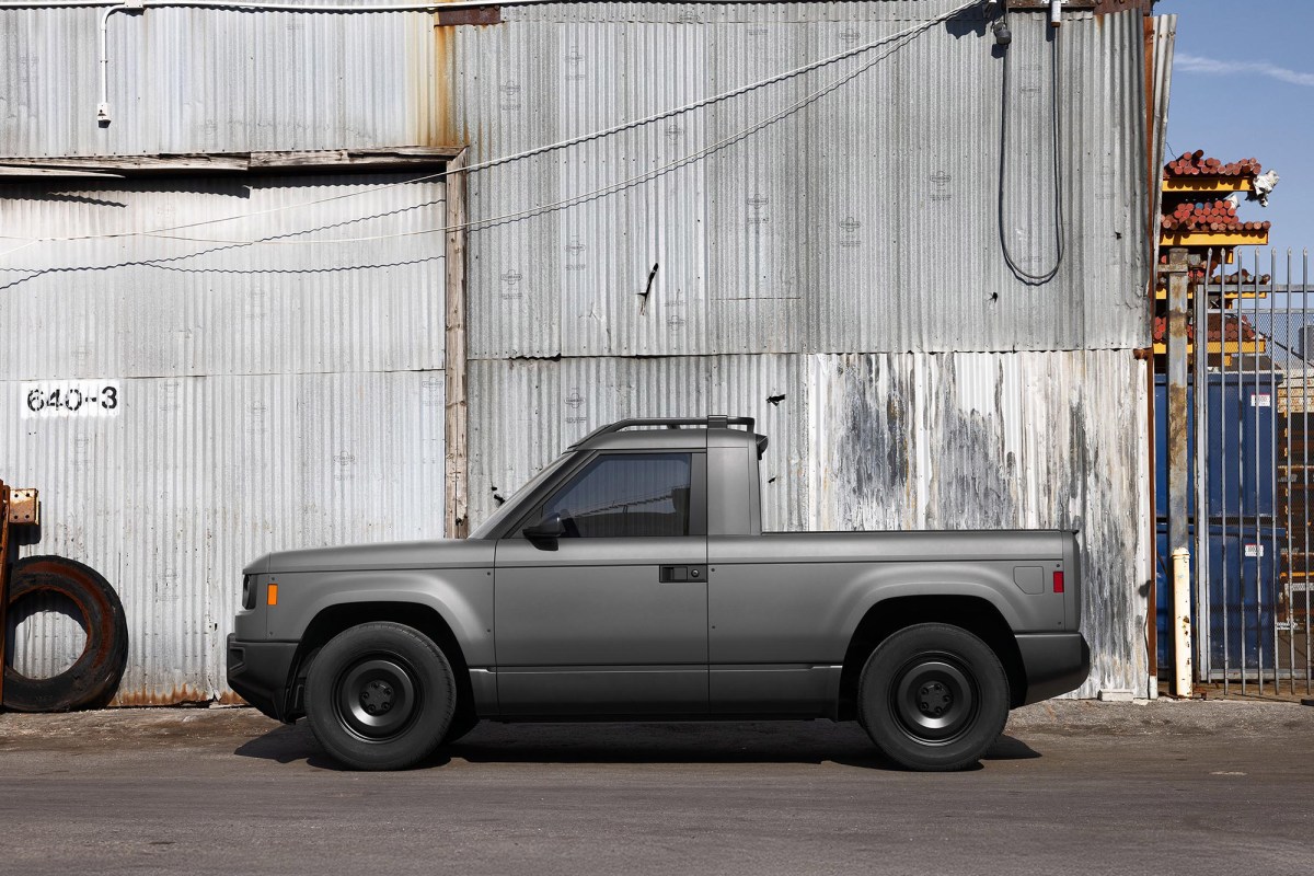 Side profile of a Slate pickup parked against a corrugated metal warehouse wall