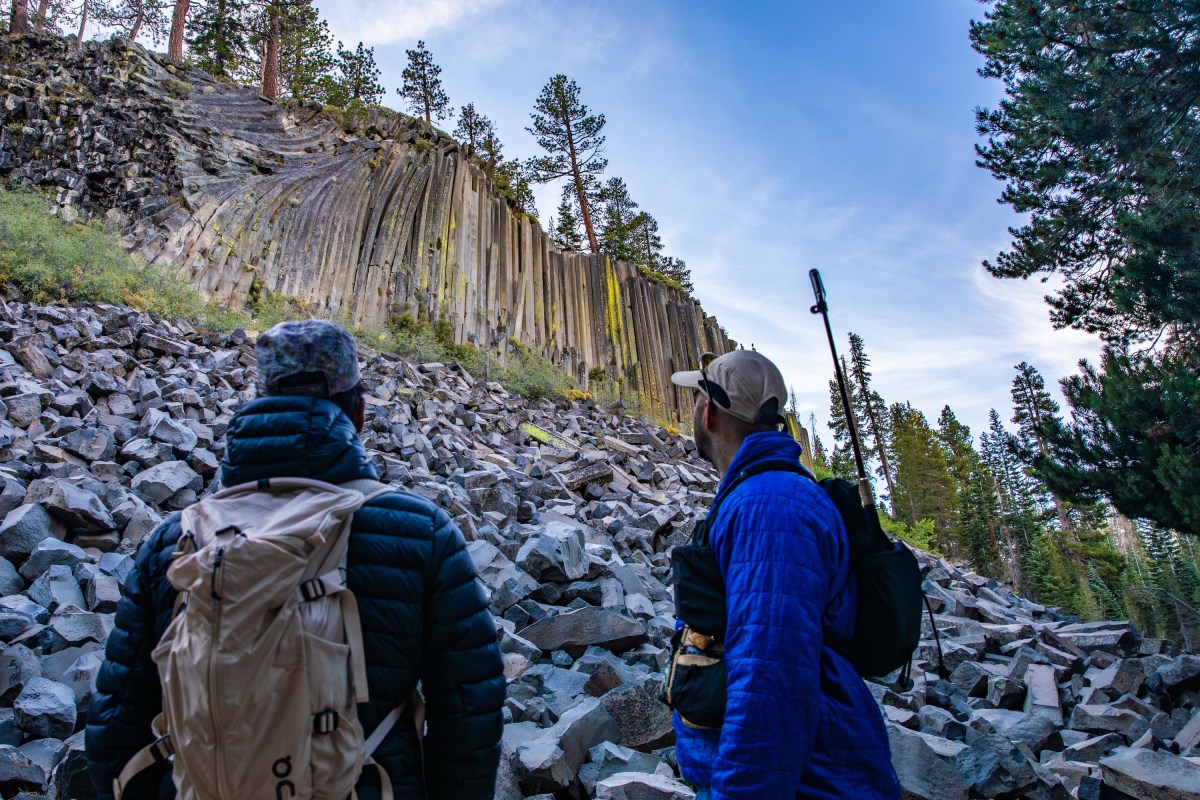 Two people looking up at Devils postpile formation