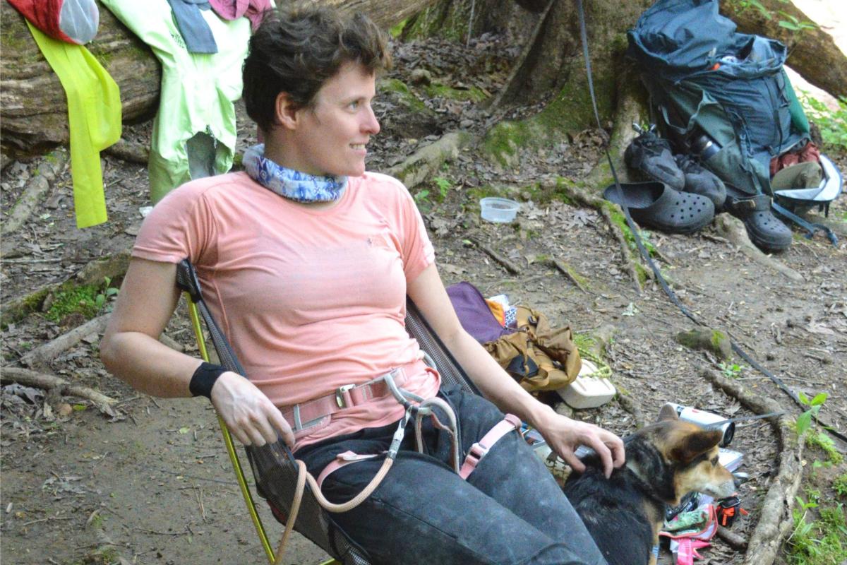 persons sits in chair pets dog
