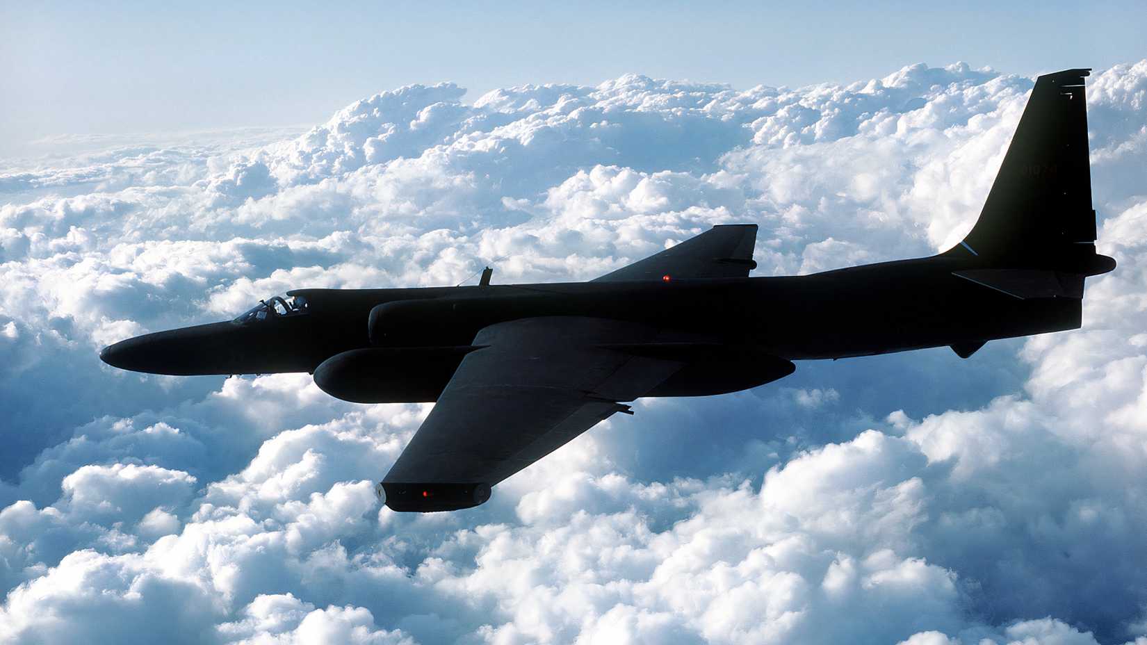 A U.S. Air Force U-2 reconnaissance aircraft flies above clouds during a high-altitude mission.