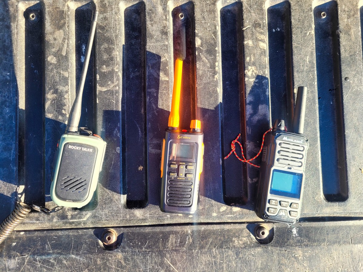 three gmrs radios sit on the tailgate of a truck during range testing
