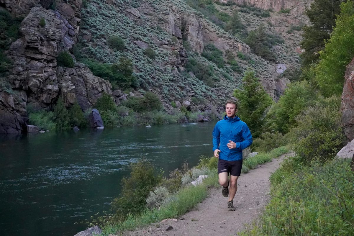 A man trail running on a path along the river