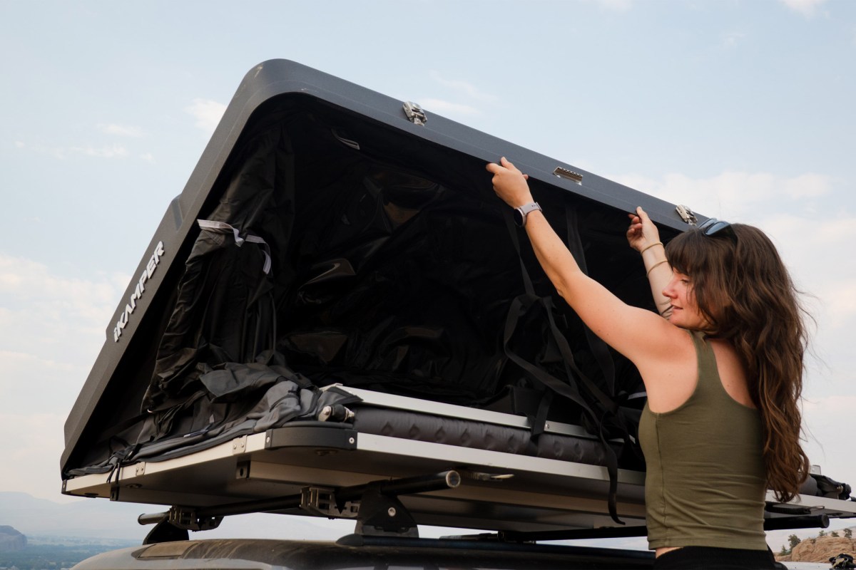 Woman lowering the hard shell on the Skycamp rooftop tent