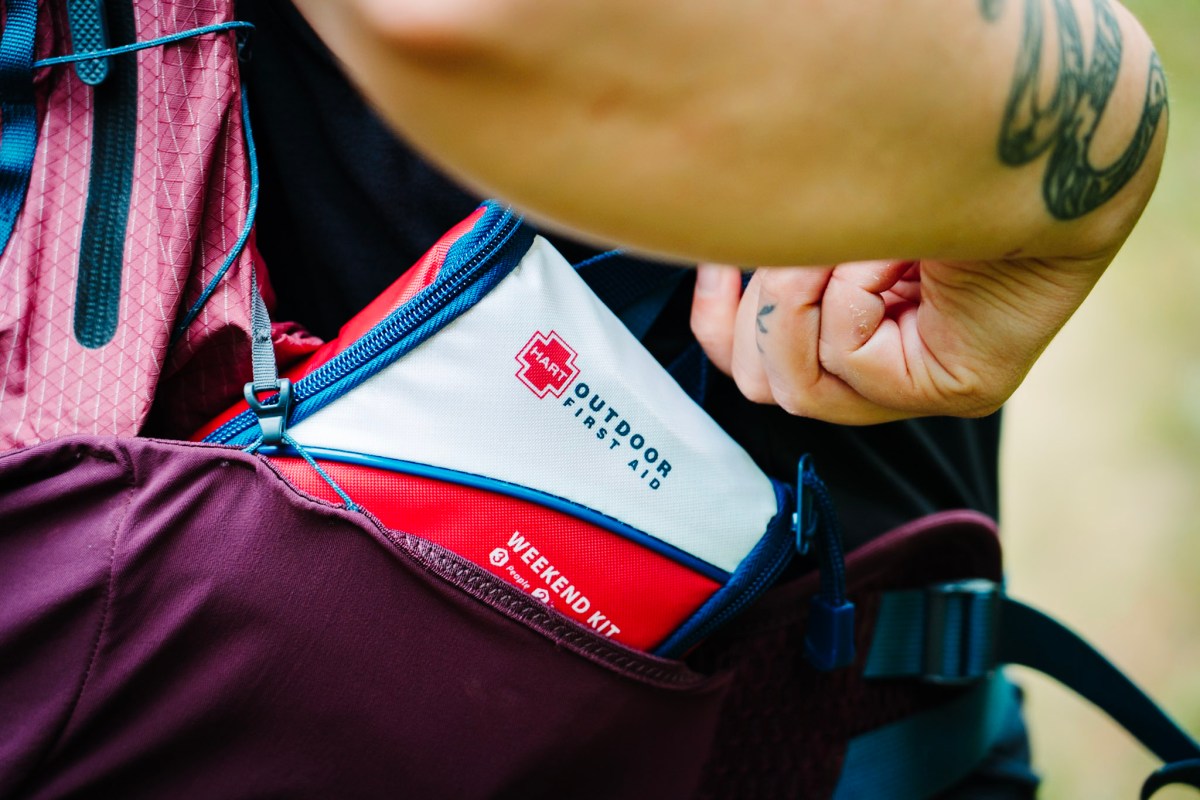 Red medical pouch tucked into a backpack side pocket