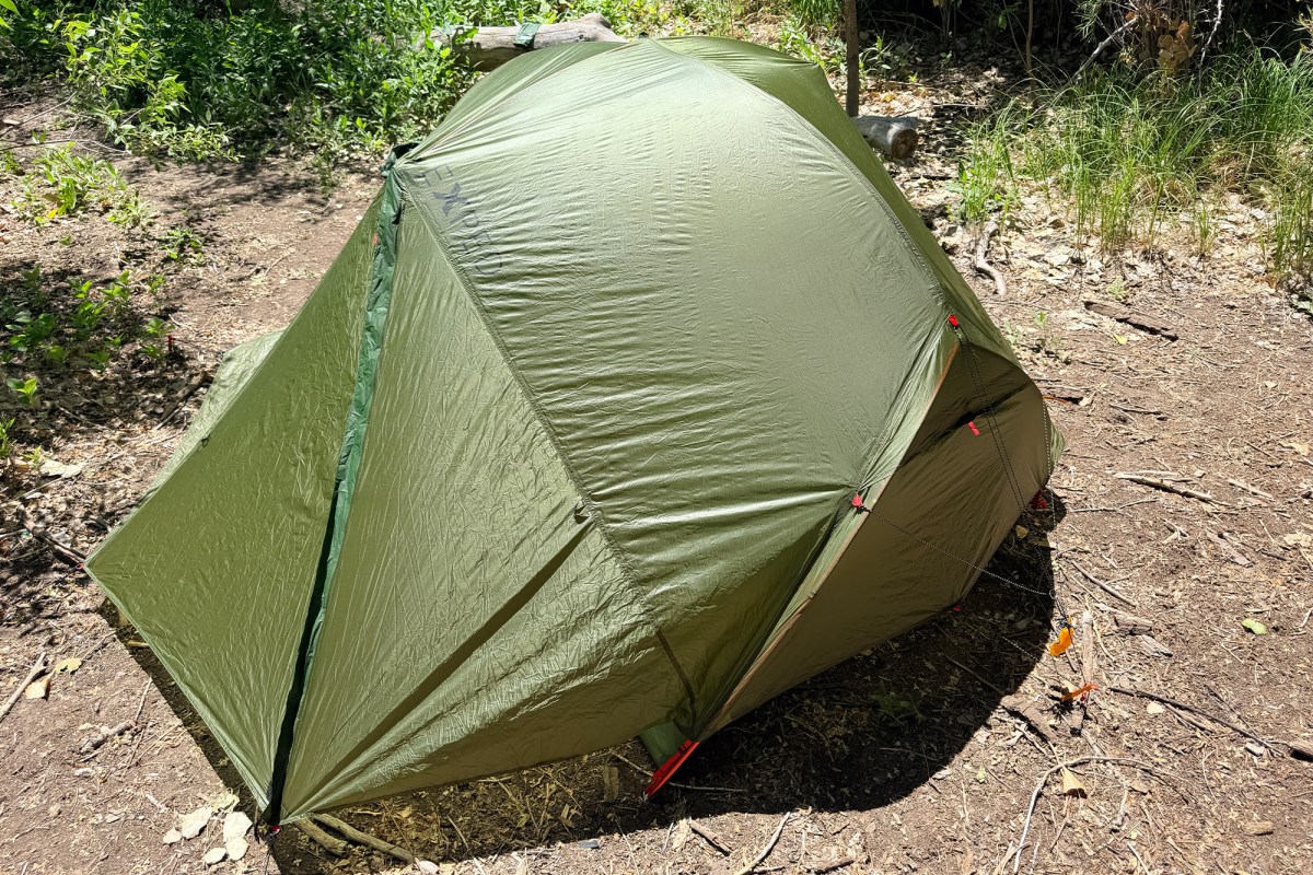 Green Cassira tent pitched with rainfly in a wooded campsite