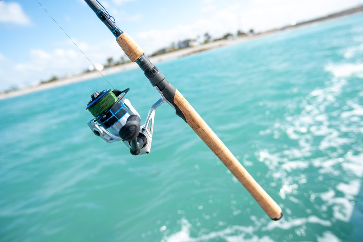 The cork handle of the H20X Factor spinning rod over the ocean.