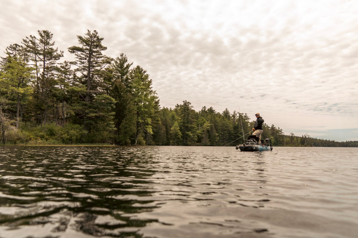An angler standing in the Old Town Sportsman 120 Pro on a lake.
