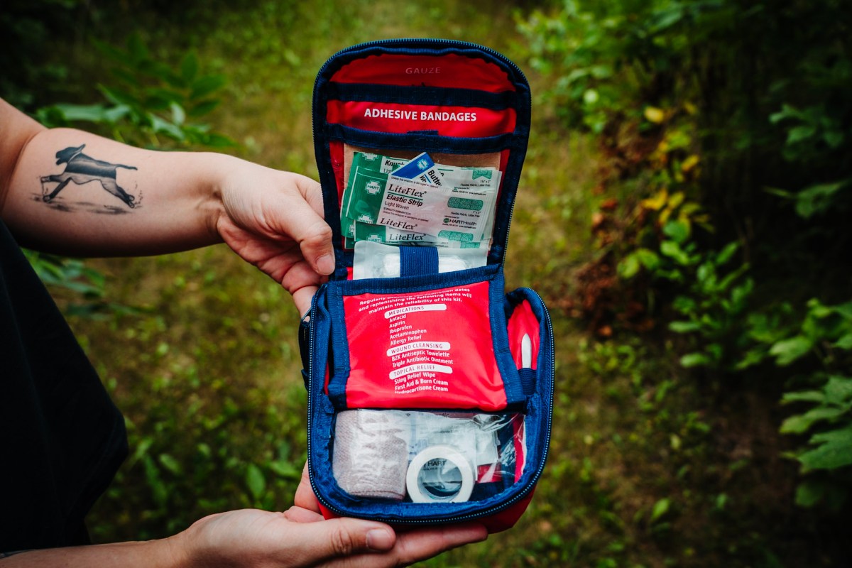 Open pouch showing bandages, gauze, tape, and medications