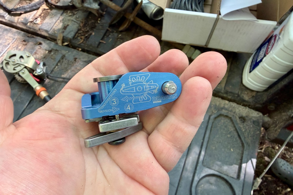 Small blue winch component held in a hand