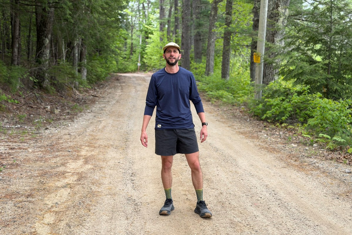 Man wearing Ripton Trail Daemon shorts on a wooded road