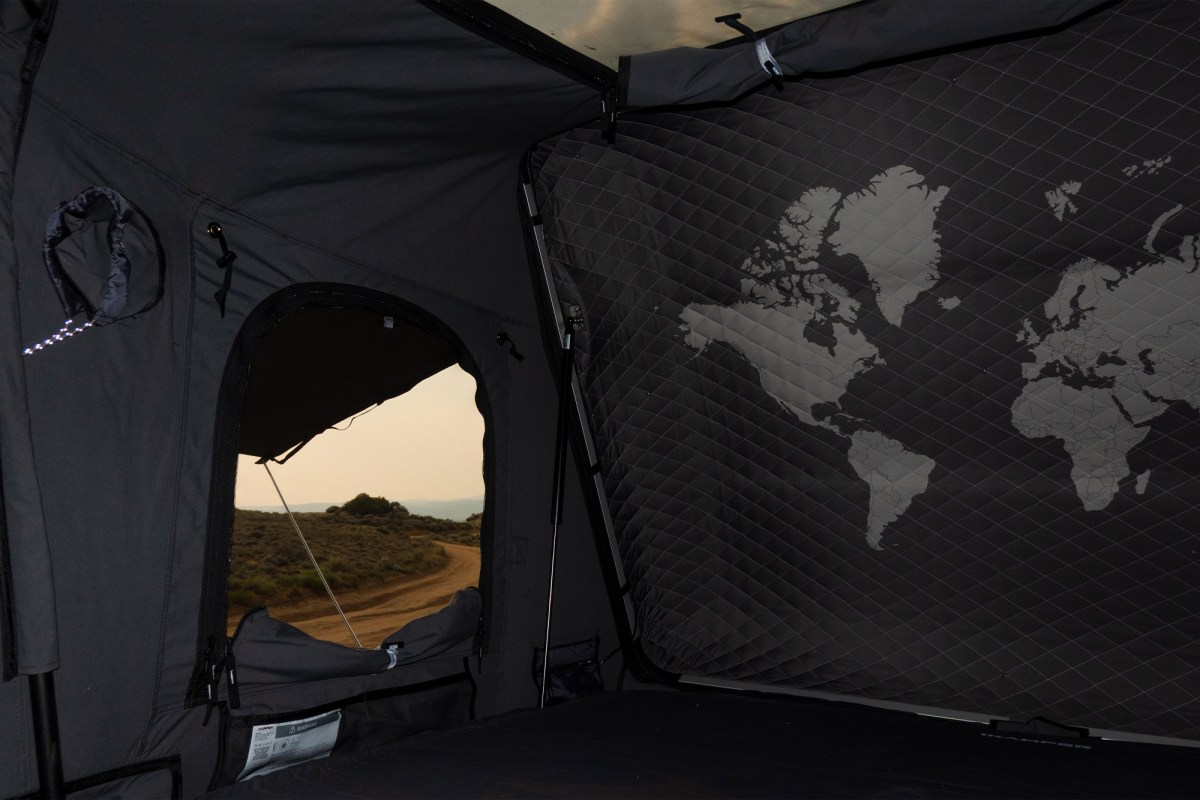 Interior of the iKamper rooftop camper with a window and world map panel