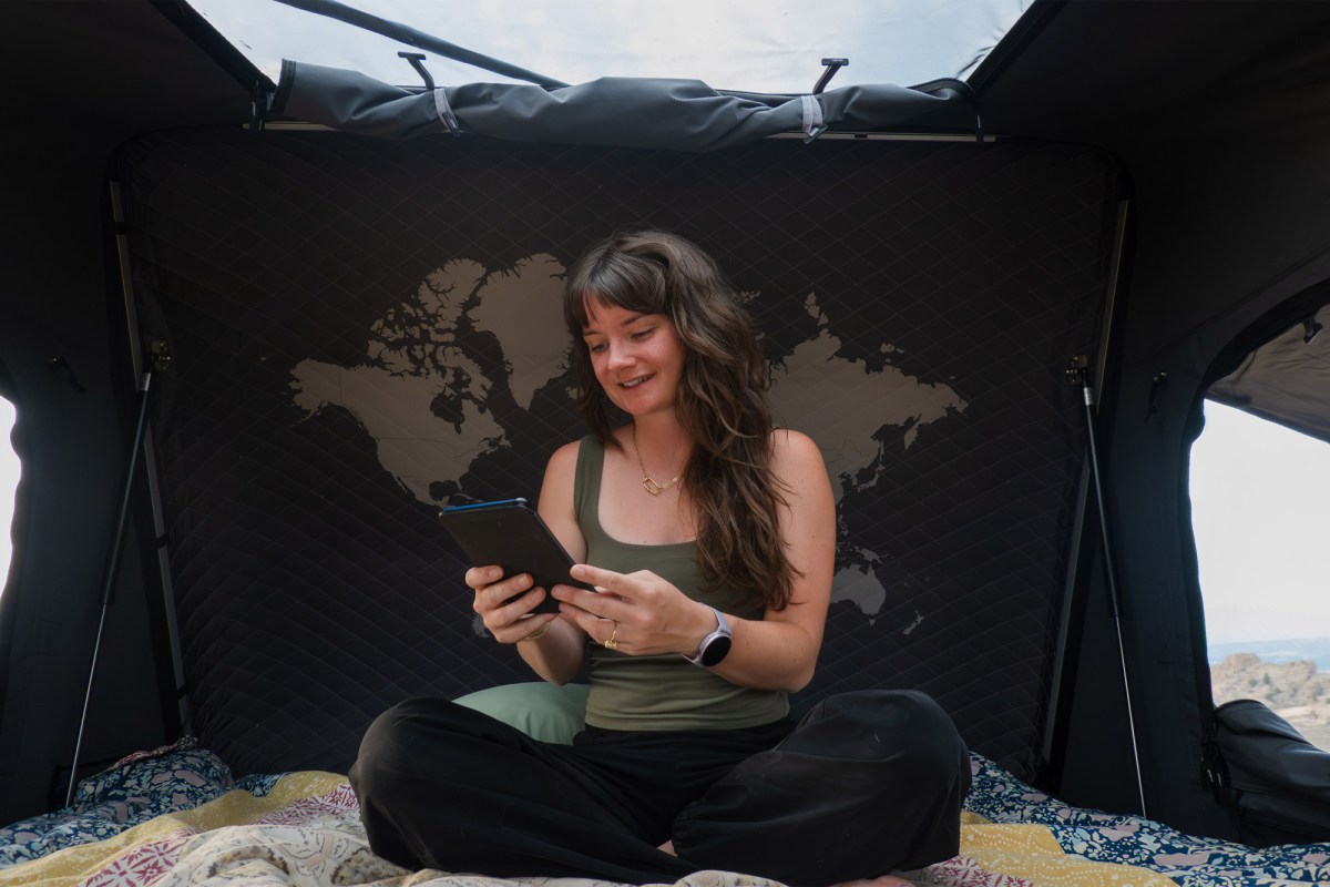 Woman using a tablet inside the iKamper rooftop camper