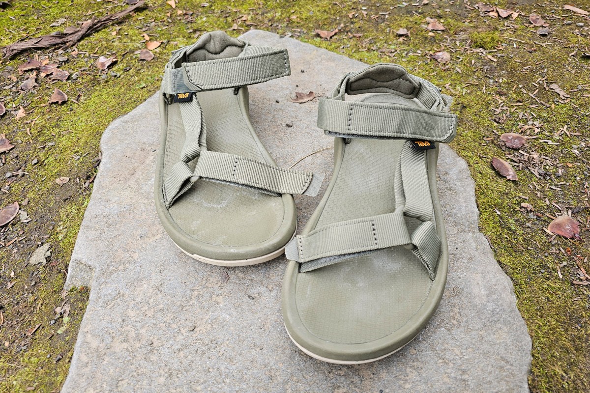 Teva Hurricane XLT3 Sandals sitting on a flat rock near moss and dry leaves