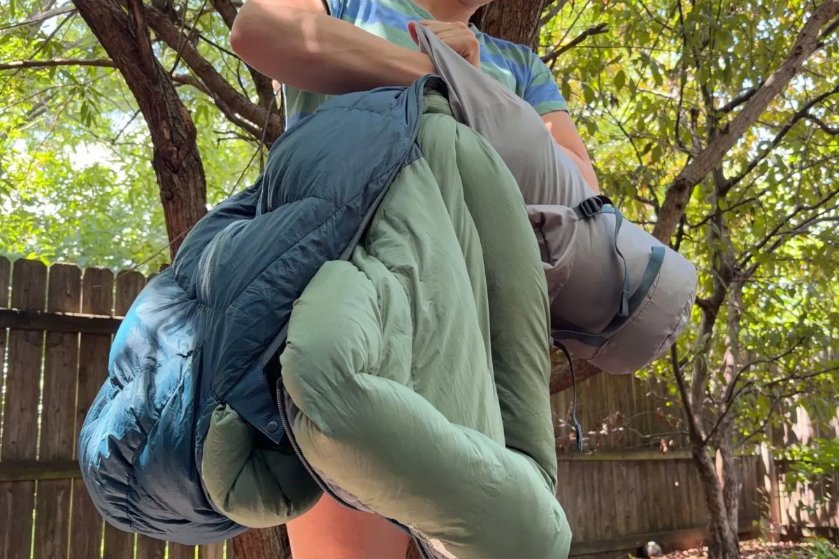 review author stuffing parsec sleeping bag into included stuff sack