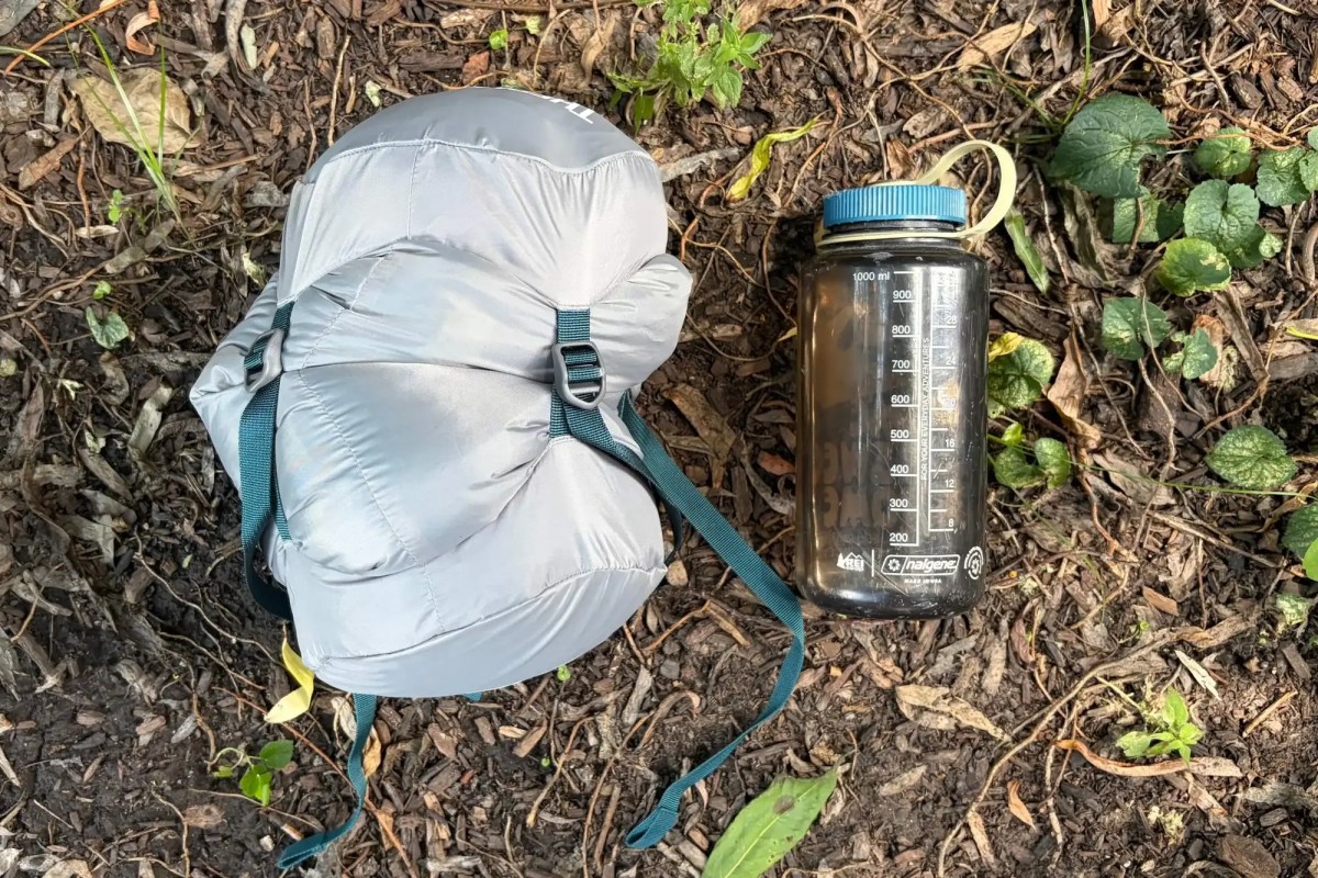 sleeping bag in stuff sack next to nalgene water bottle