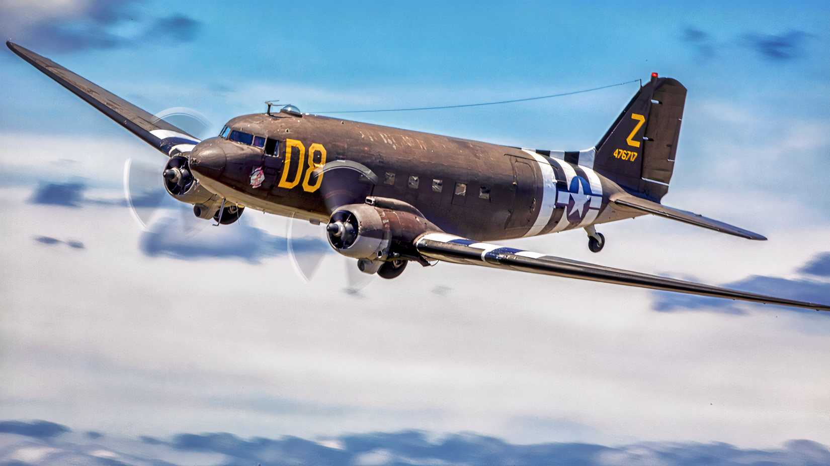 The American Airpower Museum’s Douglas C-47B Skytrain, “Second Chance,” flies in D-Day-style invasion markings.
